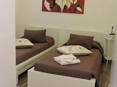 two beds sitting next to each other in a room at Appartamento Cuore Antico in Rome