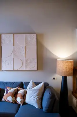 a living room with a blue couch and a lamp at Pantheon Deluxe in Rome