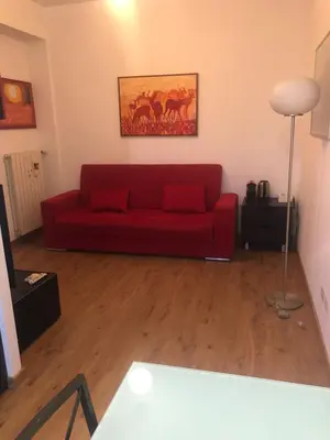 a red couch in a living room with a table at Rome center near Colosseum and metro a in Rome