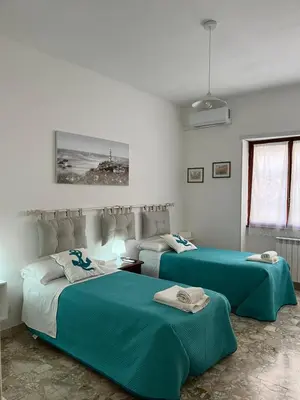 two beds in a white room with green sheets at Alloggio Turistico Perez Martinez Maria Petronila in Rome