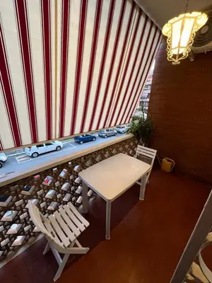 a table and chairs on a balcony with a red and white curtain at Alloggio Turistico Perez Martinez Maria Petronila in Rome