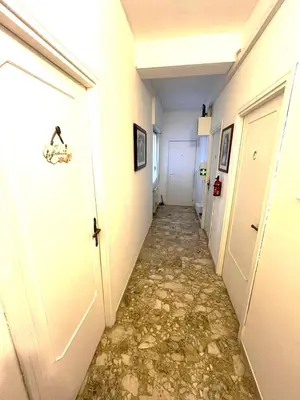 a hallway with a stone floor and white doors at Alloggio Turistico Perez Martinez Maria Petronila in Rome