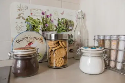 a kitchen counter with jars of cookies and flowers at La Casetta Di Nonna Anna - 120 mq Bright Apartment in Rome in Rome