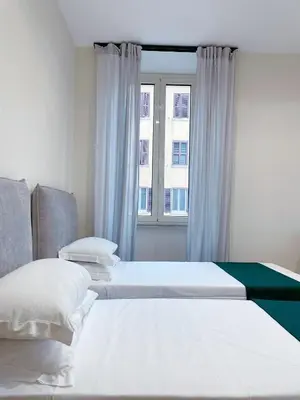 a bedroom with two beds and a window at Laterano's House in Rome