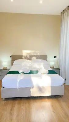a bedroom with a large bed with white sheets and pillows at Laterano's House in Rome