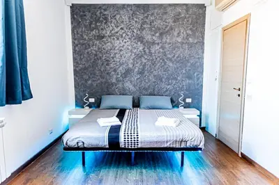 a bedroom with a bed with a gray wall at Terrace with view of Cupola San Pietro - Casa Claudia in Rome