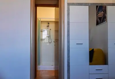 a bathroom with a white dresser and a shower at Terrace with view of Cupola San Pietro - Casa Claudia in Rome