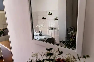 a mirror on the wall of a bathroom with a table at Terrace with view of Cupola San Pietro - Casa Claudia in Rome