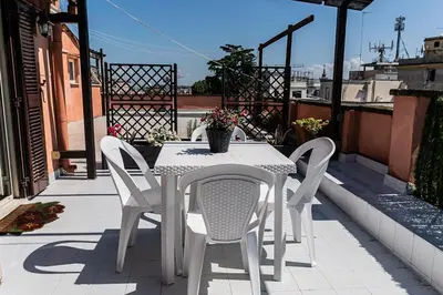 a white table and chairs on a balcony at Terrace with view of Cupola San Pietro - Casa Claudia in Rome