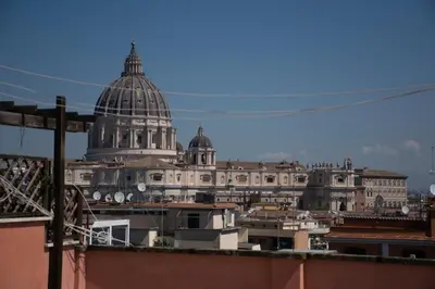 a view of a city with a domed building at Terrace with view of Cupola San Pietro - Casa Claudia in Rome