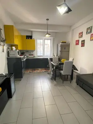 a kitchen with yellow cabinets and a table and chairs at Bittersweet Apartment in Rome