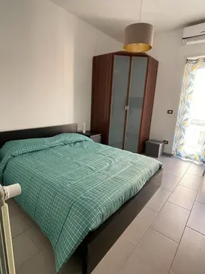 a bedroom with a bed with a green comforter at Bittersweet Apartment in Rome
