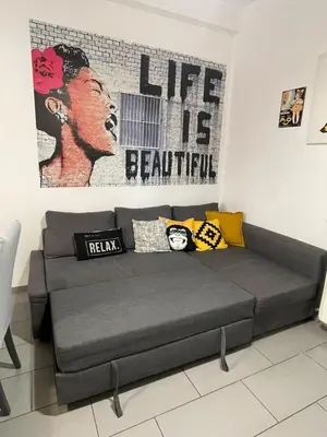 a gray couch in a room with a large painting at Bittersweet Apartment in Rome