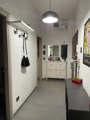a room with a white wall with a hallway with a black purse at Bittersweet Apartment in Rome