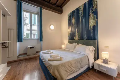 a bedroom with a large bed with a painting on the wall at Campo De Fiori Apartments in Rome