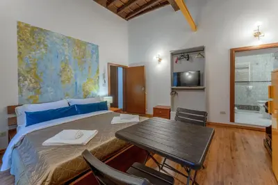 a bedroom with a bed and a table with chairs at Campo De Fiori Apartments in Rome