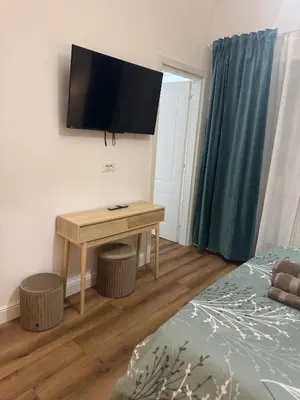 a bedroom with a desk with a television on the wall at Domus Antea in Rome