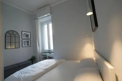 a white bedroom with a bed and a window at Camera con bagno in posizione strategica in Rome