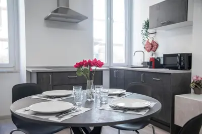 a table with plates and glasses and a vase with flowers at LUXURY BABUINO -exclusive apartment in Rome