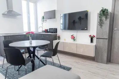 a kitchen with a table and chairs and a tv at LUXURY BABUINO -exclusive apartment in Rome