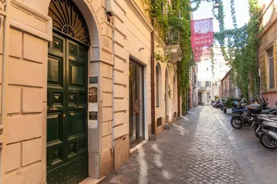 an alley with a green door on a building at LUXURY BABUINO -exclusive apartment in Rome