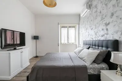 a bedroom with a bed and a flat screen tv at La Dimora Arimondi in Rome