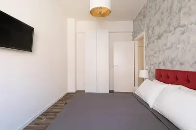 a white room with a red bed and a wall at La Dimora Arimondi in Rome