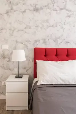 a bed with a red headboard and a nightstand with a lamp at La Dimora Arimondi in Rome