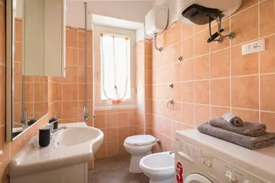 a bathroom with a white toilet and a sink at La Dimora Arimondi in Rome