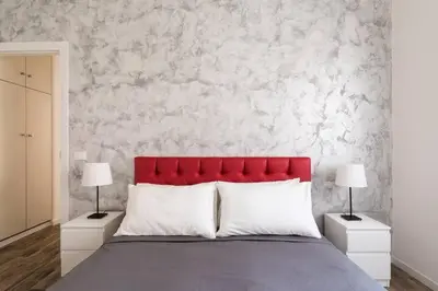 a bed with a red headboard and two night stands at La Dimora Arimondi in Rome