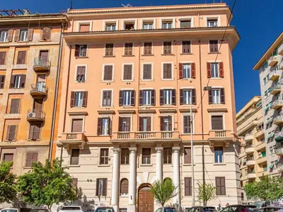a large building in a city with cars parked in front at Vatican Museums Stay with Terrace in Rome