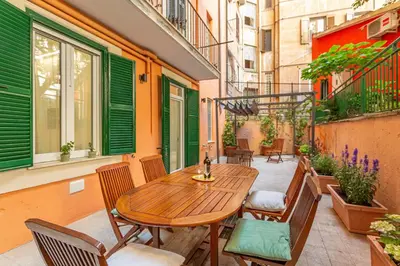 a patio with a wooden table and chairs on a balcony at Vatican Museums Stay with Terrace in Rome