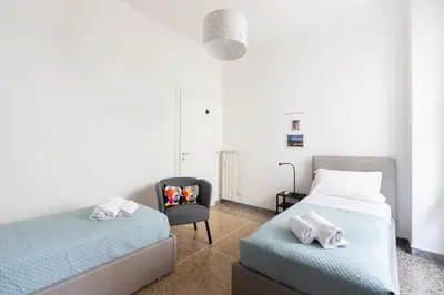 a bedroom with two beds and a chair at Macedonia 30 Bright Flat in Rome