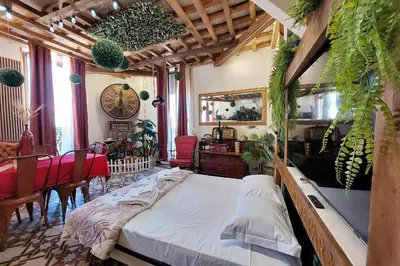 a bedroom with a bed and a dining room with plants at 4BNB - Victoria Palace in Rome