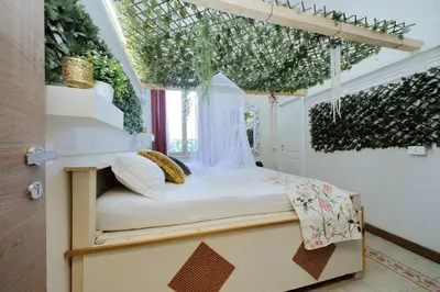 a bed in a room with plants on the ceilings at 4BNB - Victoria Palace in Rome