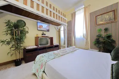 a bedroom with a white bed and a tv at 4BNB - Victoria Palace in Rome