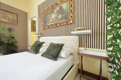 a bedroom with a bed and a painting on the wall at 4BNB - Victoria Palace in Rome