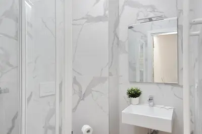 a white bathroom with a sink and a shower at Sabelli 1 Villa Indipendente nel Cuore di Roma in Rome