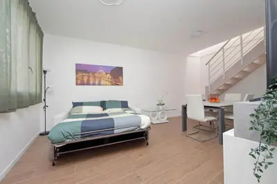 a bedroom with a bed and a desk and a staircase at Sabelli 1 Villa Indipendente nel Cuore di Roma in Rome