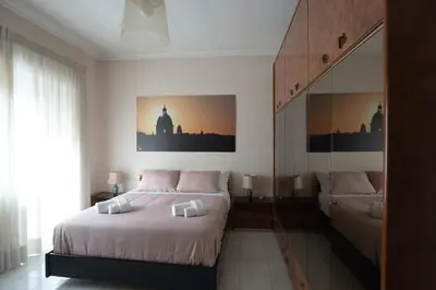 a bedroom with a large bed and a mirror at Happio Apartment in Rome in Rome