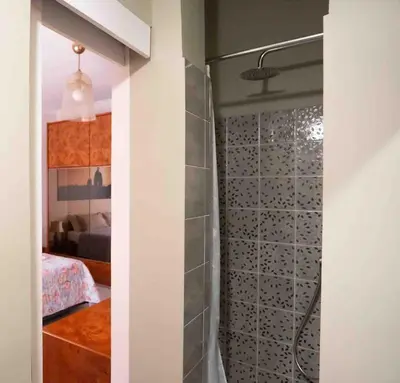 a bathroom with a walk in shower next to a bedroom at Happio Apartment in Rome in Rome