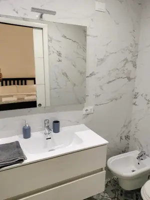 a white bathroom with a sink and a mirror at Vatican room - all you need to sleep 1 in Rome