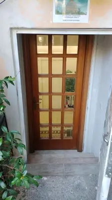 a wooden door with a window in a hallway at Vatican room - all you need to sleep 1 in Rome