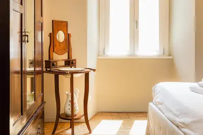 a room with a bed and a table with a mirror at Amazing 3 Bedrooms Prati Vatican in Rome