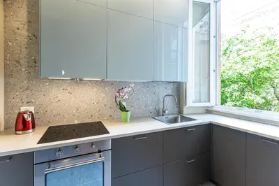 a kitchen with blue cabinets and a sink and a window at Amazing 3 Bedrooms Prati Vatican in Rome