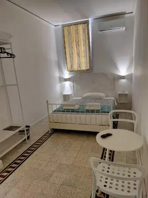 a small bedroom with a bed and a table and a table at Vatican Room -all you need to sleep 2 in Rome