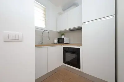 a white kitchen with a sink and a microwave at Sabelli 2 Villa Indipendente nel Cuore di Roma in Rome