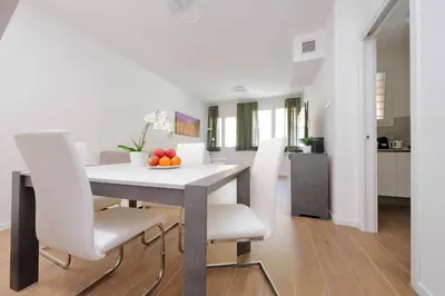 a dining room with a white table and white chairs at Sabelli 3 Villa Indipendente con Studio Privato in Rome