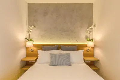 a bedroom with a large white bed with two lamps at The Spanish Suite Campo de' Fiori in Rome