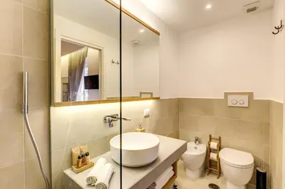a bathroom with a sink and a toilet and a mirror at The Spanish Suite Campo de' Fiori in Rome